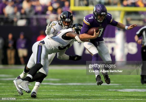 Case Keenum of the Minnesota Vikings runs with the ball while being pursued by defenders C.J. Mosley and Za'Darius Smith of the Baltimore Ravens in...