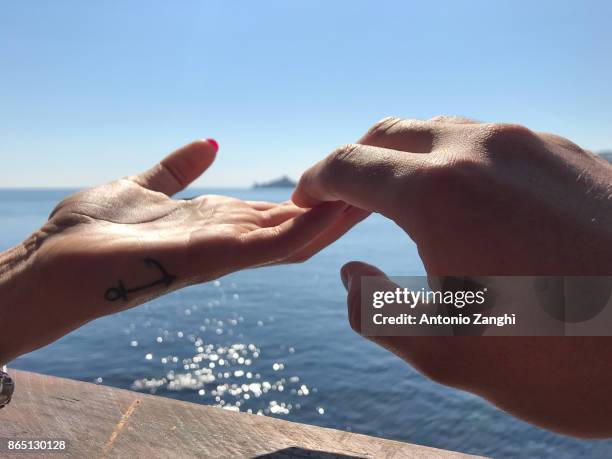 close-up couple hands in a sea background - acireale stock pictures, royalty-free photos & images