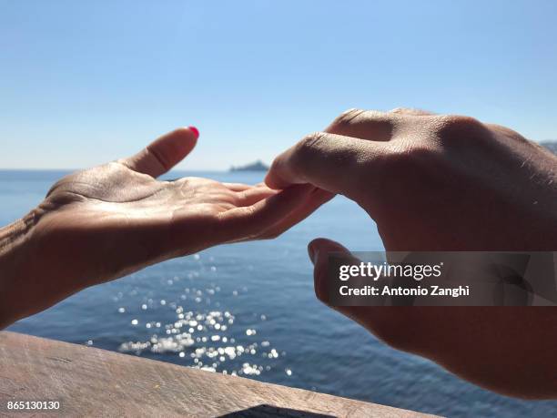 close-up couple hands in a sea background - acireale stock pictures, royalty-free photos & images