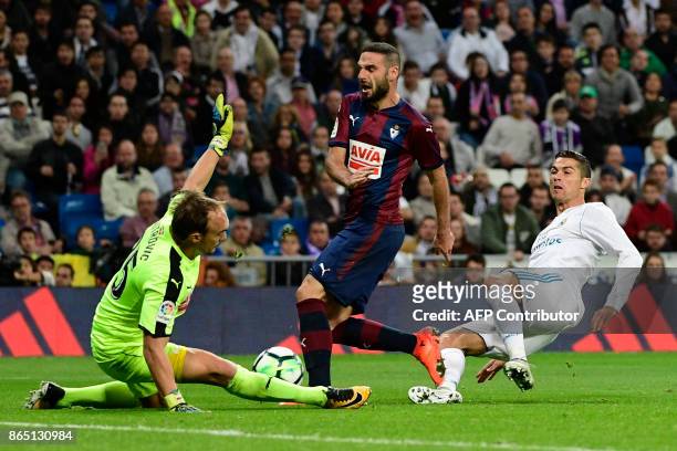 Eibar's Serbian goalkeeper Marko Dmitrovic and Eibar's Spanish defender David Lomban block a shot on goal by Real Madrid's Portuguese forward...