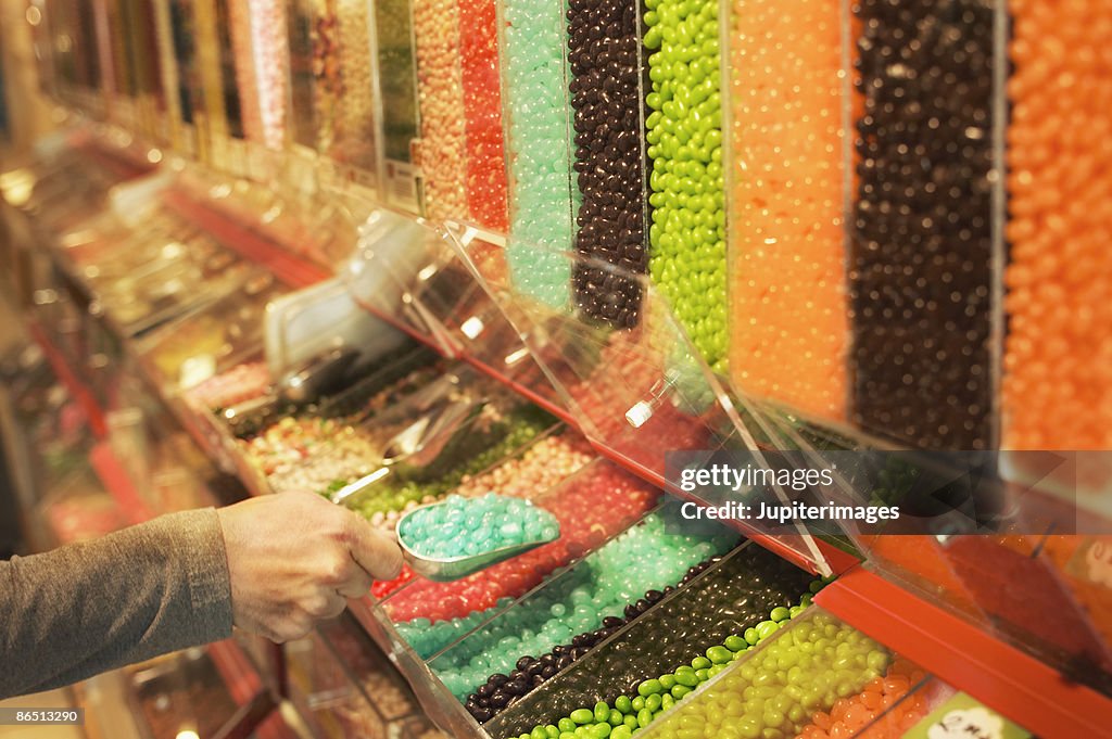 Woman scooping jelly beans in candy store