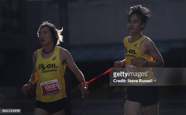 Young Won Kim guides Jun Sung Park up the final street of Bay Street in the half-marathon during the Scotiabank Toronto Waterfront Marathon in...
