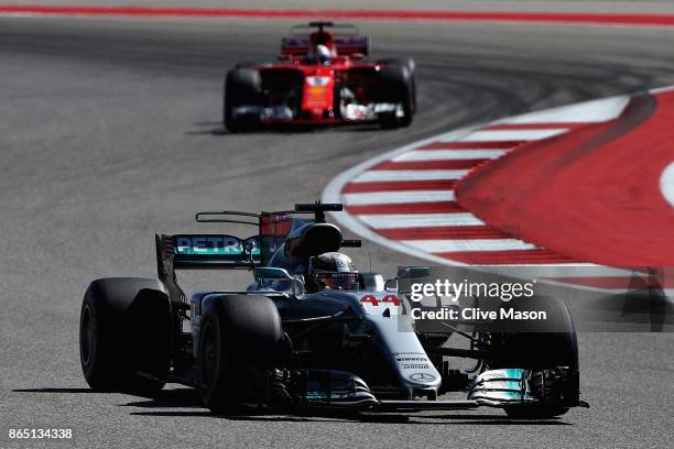 Lewis Hamilton of Great Britain driving the Mercedes AMG Petronas F1 Team Mercedes F1 WO8 leads Sebastian Vettel of Germany driving the Scuderia...