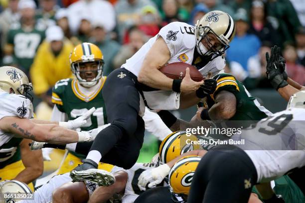 Drew Brees of the New Orleans Saints scores a touchdown on a quarterback sneak in the fourth quarter against the Green Bay Packers at Lambeau Field...