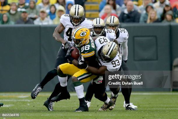 David Onyemata of the New Orleans Saints tackles Ty Montgomery of the Green Bay Packers in the fourth quarter at Lambeau Field on October 22, 2017 in...