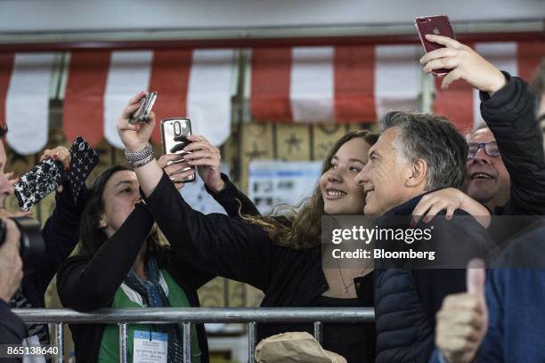 Mauricio Macri, Argentina's president, right, takes a selfie photograph with a voter at a polling station in Buenos Aires, Argentina, on Sunday, Oct....