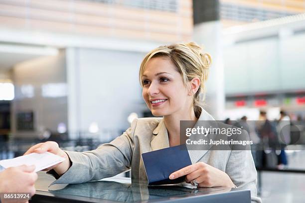 businesswoman checking in at airport ticket counter - biglietteria foto e immagini stock