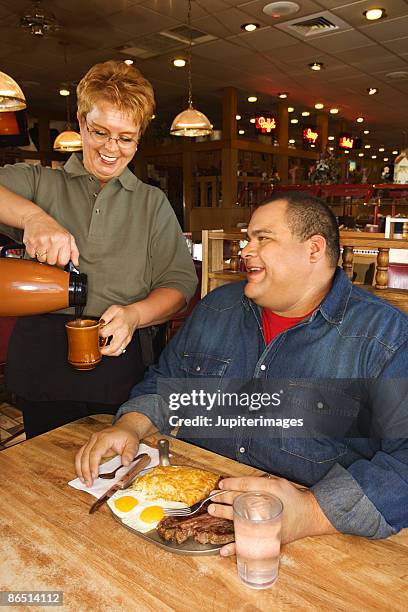 man in restaurant with waitress - waitress booth stock pictures, royalty-free photos & images
