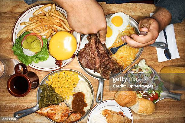 man eating from multiple plates of food - man eating pie stock pictures, royalty-free photos & images