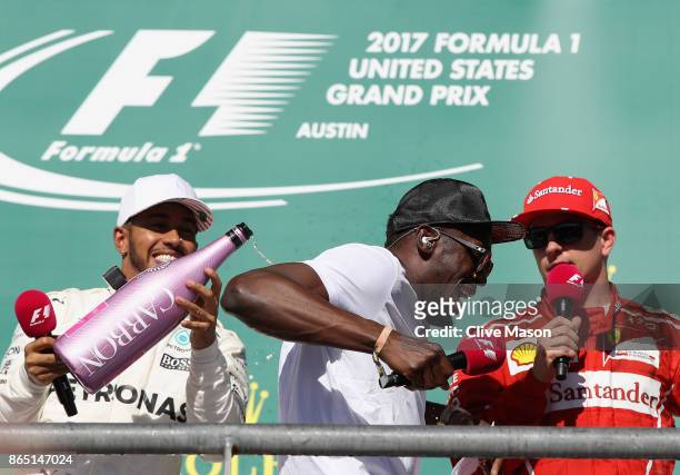 Race winner Lewis Hamilton of Great Britain and Mercedes GP celebrates on the podium with sprinting legend Usain Bolt and Kimi Raikkonen of Finland...