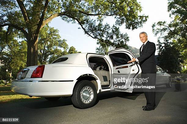 limousine chauffeur opening door - limo stockfoto's en -beelden