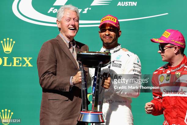 Race winner Lewis Hamilton of Great Britain and Mercedes GP with former President of the USA Bill Clinton and third place finisher Kimi Raikkonen of...