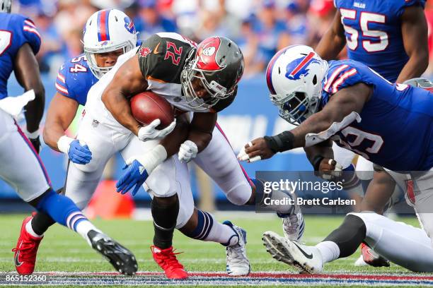 Doug Martin of the Tampa Bay Buccaneers runs the ball as Eddie Yarbrough of the Buffalo Bills and Marcell Dareus of the Buffalo Bills attempt to...