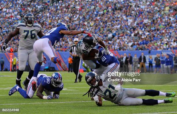Tyler Lockett of the Seattle Seahawks is taclked by Ross Cockrell and Landon Collins of the New York Giants during the first half of the game at...