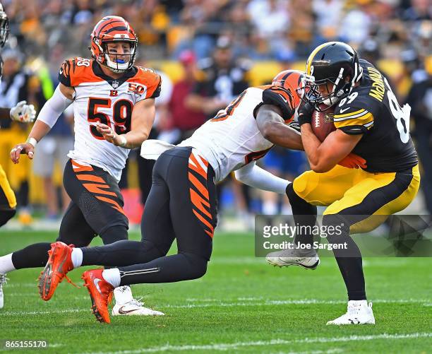 Vance McDonald of the Pittsburgh Steelers is wrapped up for a tackle by George Iloka of the Cincinnati Bengals in the first half during the game at...
