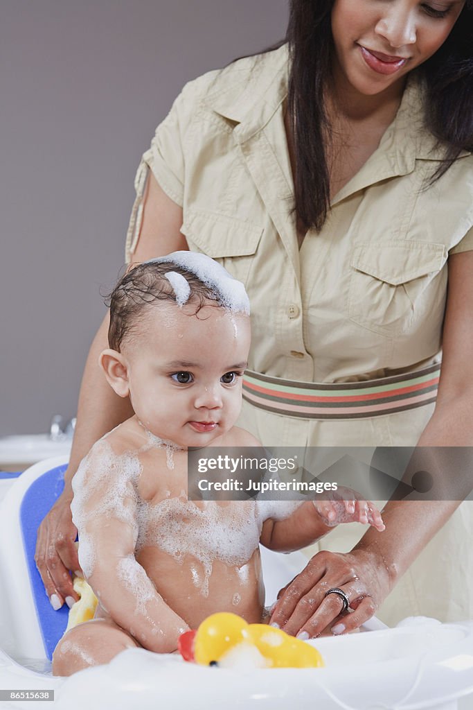 Mother bathing baby