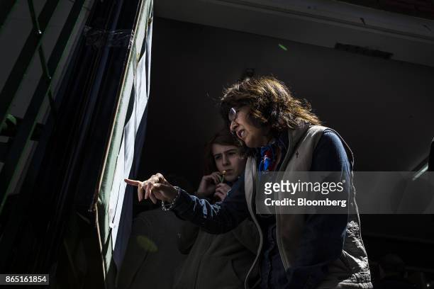 Voters check a registration list outside of a polling station in Buenos Aires, Argentina, on Sunday, Oct. 22, 2017. Argentines will have the...