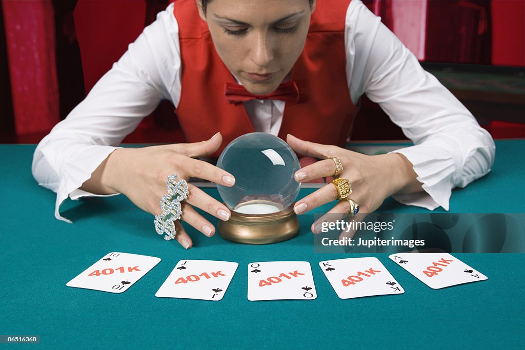 Casino dealer with crystal ball and investment playing cards