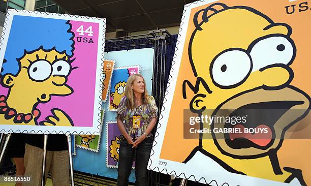 Actress Nancy Cartwright poses close to the unveiled stamps of the Simpsons characters at the Fox Studios in Los Angeles, California, on May 7 during...