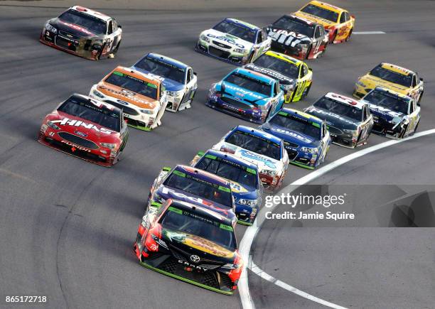 Martin Truex Jr., driver of the Bass Pro Shops/Tracker Boats Toyota, leads a pack of cars during the Monster Energy NASCAR Cup Series Hollywood...