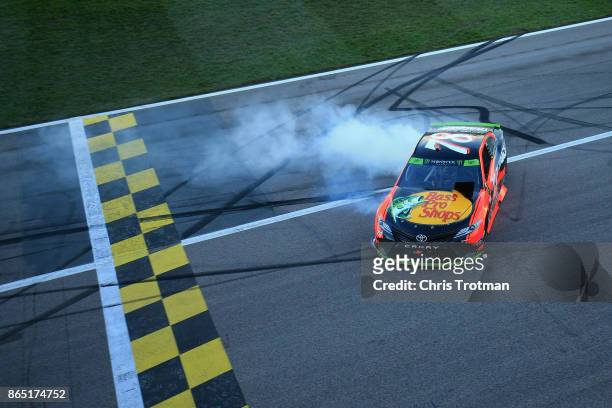Martin Truex Jr., driver of the Bass Pro Shops/Tracker Boats Toyota, celebrates with a burnout after winning the Monster Energy NASCAR Cup Series...