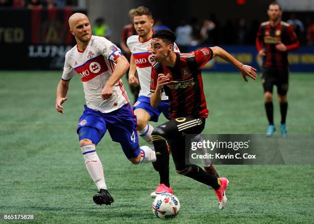 Miguel Almiron of Atlanta United pushes the ball against Michael Bradley of Toronto FC at Mercedes-Benz Stadium on October 22, 2017 in Atlanta,...