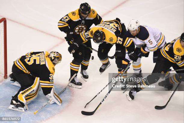 Anton Khudobin, Torey Krug, Patrice Bergeron and Brandon Carlo of the Boston Bruins watch the loose puck against Matt Tennyson of the Buffalo Sabres...