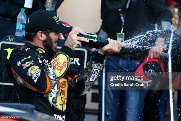 Martin Truex Jr., driver of the Bass Pro Shops/Tracker Boats Toyota, celebrates in Victory Lane after winning the Monster Energy NASCAR Cup Series...