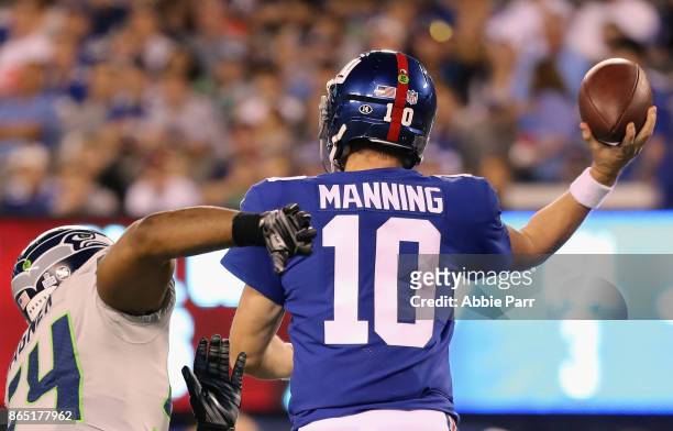 Quarterbackc Eli Manning of the New York Giants throws a pass against Bobby Wagner of the Seattle Seahawks during the third quarter of the game at...