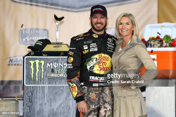 Martin Truex Jr., driver of the Bass Pro Shops/Tracker Boats Toyota, and girlfriend, Sherry Pollex, pose for a photo with the trophy in Victory Lane...