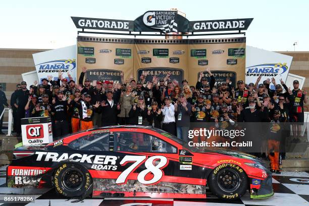 Martin Truex Jr., driver of the Bass Pro Shops/Tracker Boats Toyota, and his crew pose for a photo with the trophy in Victory Lane after winning the...