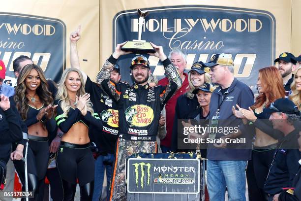 Martin Truex Jr., driver of the Bass Pro Shops/Tracker Boats Toyota, celebrates with the trophy in Victory Lane after winning the Monster Energy...