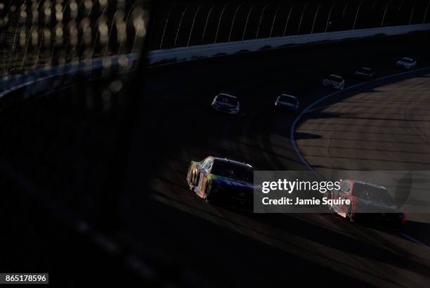 Kyle Busch, driver of the M&M's Halloween Toyota, and the Martin Truex Jr., driver of the Bass Pro Shops/Tracker Boats Toyota, race during the...