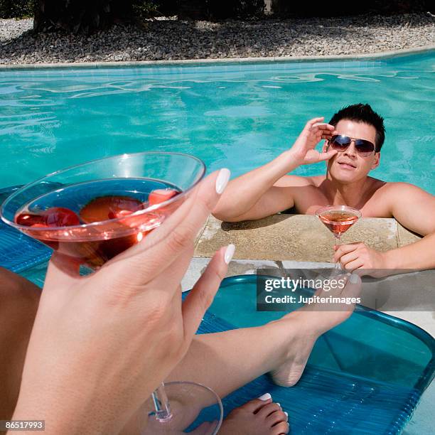 couple drinking cocktails poolside - man pedicure chair stock pictures, royalty-free photos & images