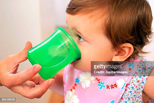 baby drinking - baby cup fotografías e imágenes de stock