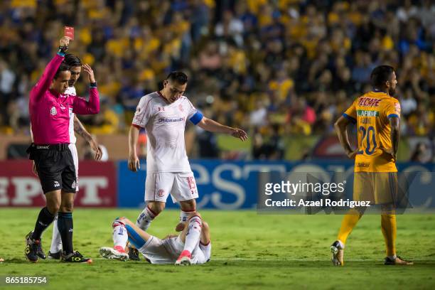Referee Jorge Rojas gives a red card to Javier Aquino of Tigres during the 14th round match between Tigres UANL and Toluca as part of the Torneo...