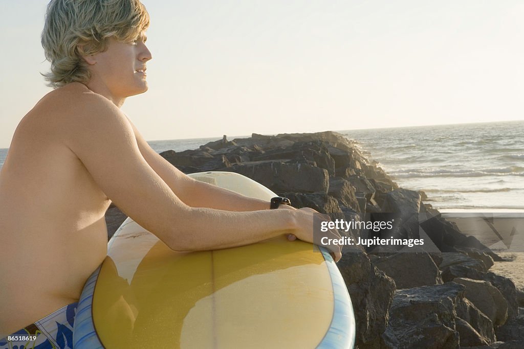 Man holding surfboard on beach