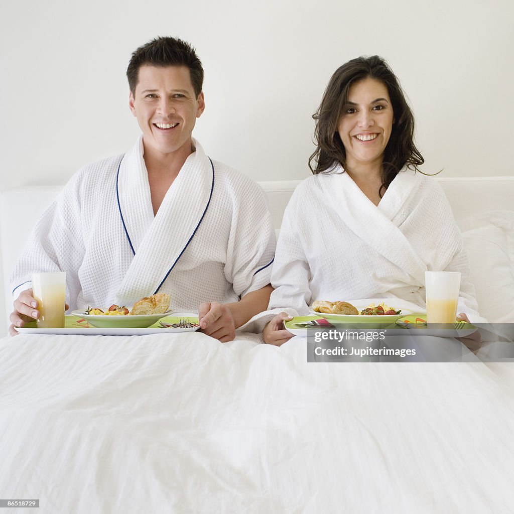 Smiling couple with breakfast in bed