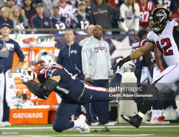 Rob Gronkowski of the New England Patriots makes a diving catch as he is defended by Duke Riley of the Atlanta Falcons during the first quarter of a...