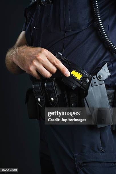 police officer and stun gun - police taser 個照片及圖片檔