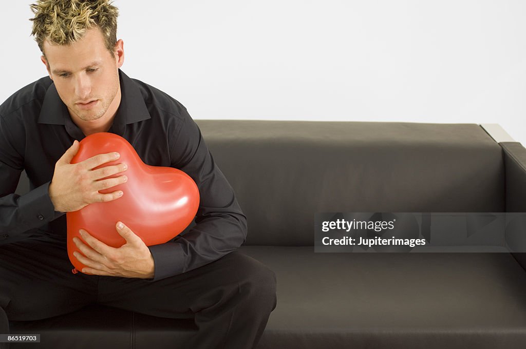 Man holding heart-shaped balloon