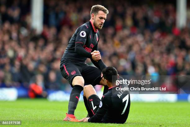 Aaron Ramsey of Arsenal helps Alexis Sanchez of Arsenal up from the ground during the Premier League match between Everton and Arsenal at Goodison...