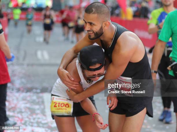 Carolyn Kim is emotional and consoled by Saeed Osman at the finish line during the Scotiabank Toronto Waterfront Marathon in Toronto. October 22,...