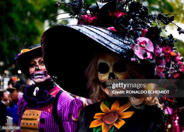 People fancy dressed as "Catrina" take part in the "Catrinas Parade" along Reforma Avenue, in Mexico City on October 22, 2017. - Mexicans get ready...