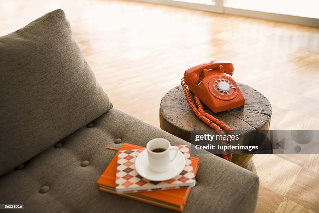 Rotary telephone and cup of coffee on sofa