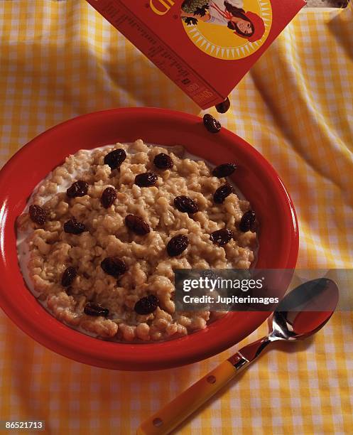 raisins pouring over oatmeal - oatmeal raisin stock pictures, royalty-free photos & images