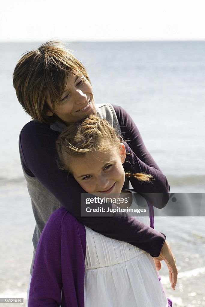 Mother and daughter hugging at beach