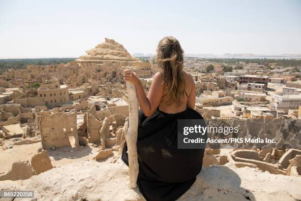 young woman looks across shali fortress from raised viewpoint - siwa photos et images de collection