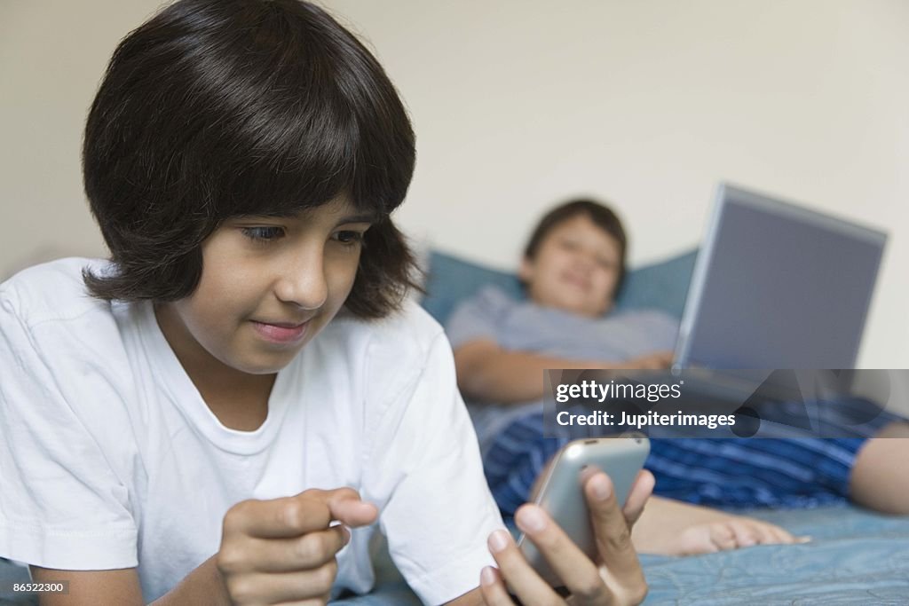 Boys with cell phone and laptop