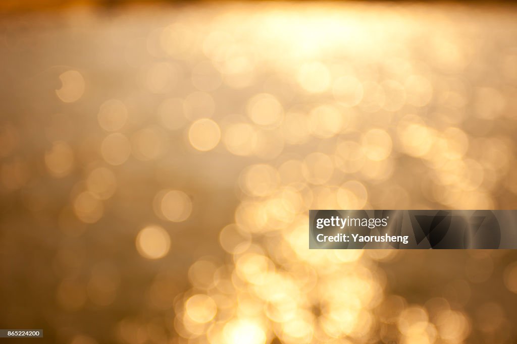 Blur sunset beach with bokeh sun light wave abstract background